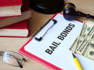 clipboard with paper reading 'bail bonds' with stacks of hundred dollar bills