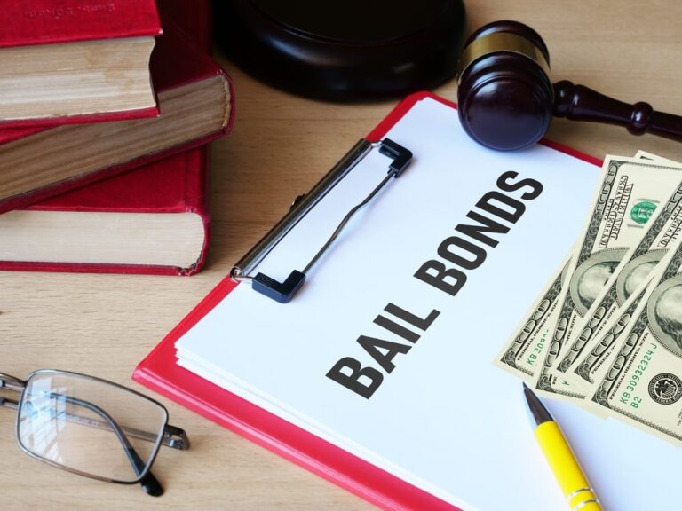 clipboard with paper reading 'bail bonds' with stacks of hundred dollar bills